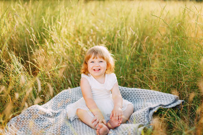 Portrait of smiling boy sitting on grass