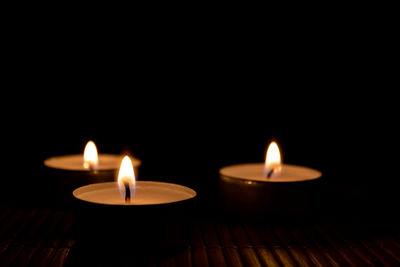 Close-up of lit candles in the dark