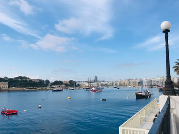 Sailboats in city against sky