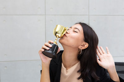 Young woman kissing trophy 
