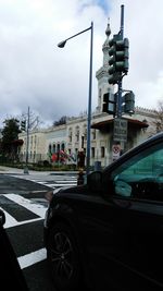 Cars on city street against sky