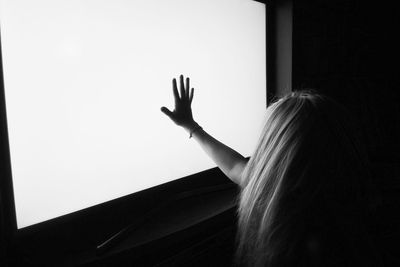 Close-up of girl with long hair touching television set