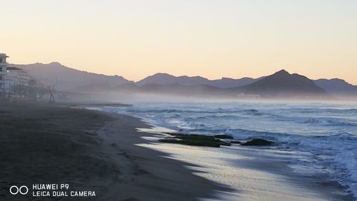 Scenic view of beach against sky during sunset