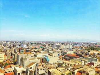 High angle shot of cityscape against blue sky