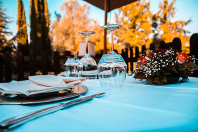 Close-up of empty wineglasses by decoration on tables at sidewalk cafe