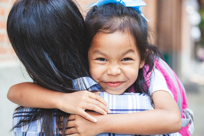 Portrait of girl embracing mother