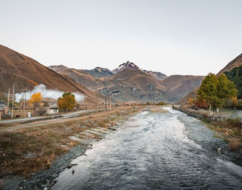 Road amidst mountains against clear sky