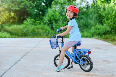 Cheerful girl riding bicycle outdoors