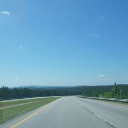 Road against clear blue sky