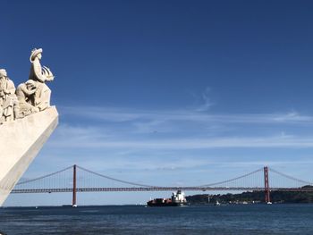 View of lisbon river bridge against cloudy sky