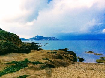 Scenic view of sea and mountains against sky