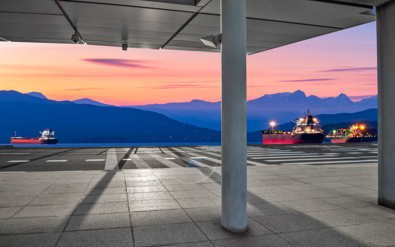 AIRPORT RUNWAY AGAINST MOUNTAINS DURING SUNSET