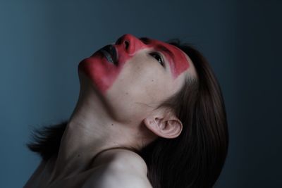 Close-up of young woman against gray background