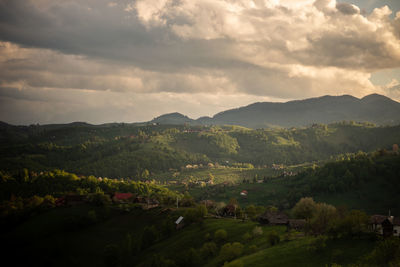 Orange sunset over green hills in a countryside scenery