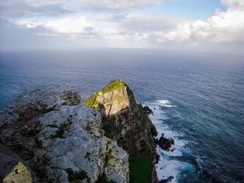 Rock formation in sea against sky