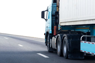 Vehicles on road against clear sky