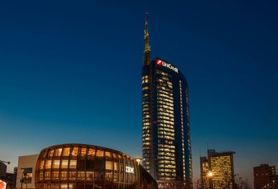 Low angle view of illuminated buildings against blue sky