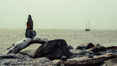 Stack of pebbles on beach against sky