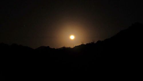 Scenic view of silhouette moon against clear sky during sunset