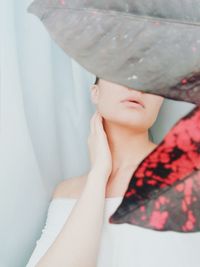 Woman covering face with leaves