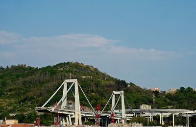 Bridge over river in city against sky