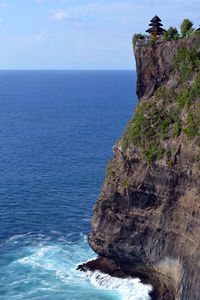 Rock formation by sea against sky