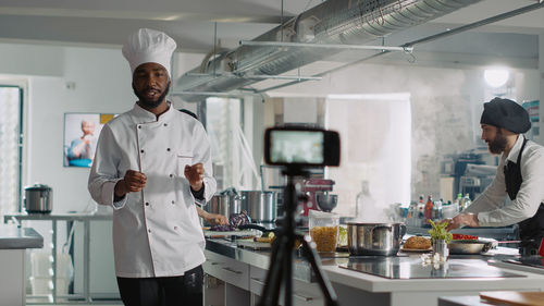 Male chef vlogging in kitchen