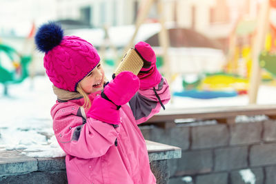 Portrait of cute smiling girl enjoying on snow