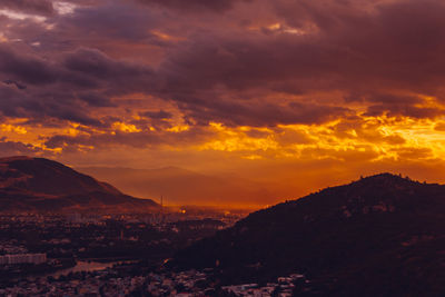 Aerial view of townscape against orange sky