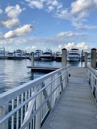 Boats moored at harbor against sky