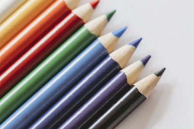 Multi-colored coloring pencils on white background