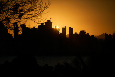 Silhouette buildings against sky during sunset