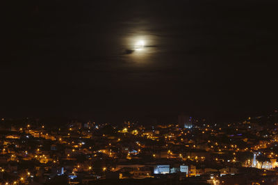 High angle view of illuminated buildings against sky at night