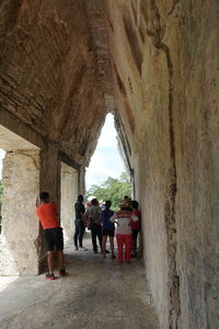 Rear view of people walking in historical building