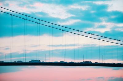 View of suspension bridge against cloudy sky