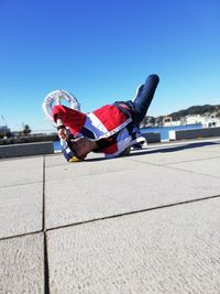 Boy on umbrella against blue sky