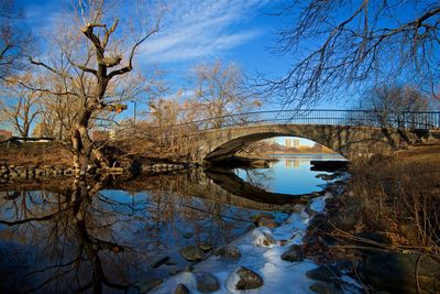 Arch bridge over lake against sky