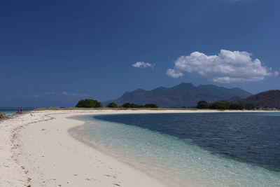 Scenic view of beach against blue sky