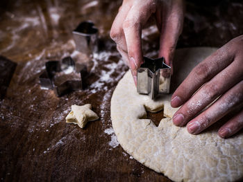 Cropped hand preparing cookies at table