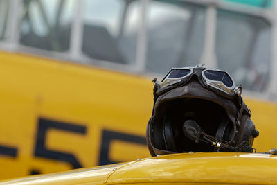 Close-up of crash helmet on vehicle with bus in background