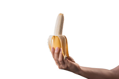 Close-up of hand holding apple against white background