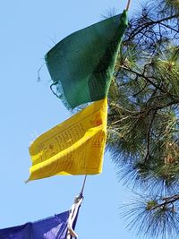 Low angle view of yellow flag against clear sky