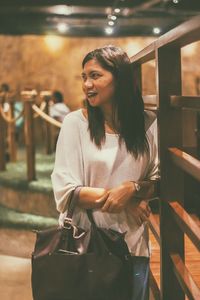 Young woman looking down while standing on railing