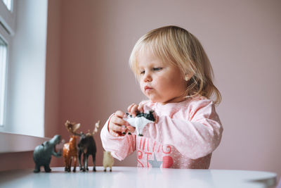 Portrait of cute girl playing with toys at home