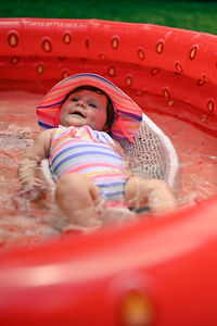 Full length of cute girl lying in red hat