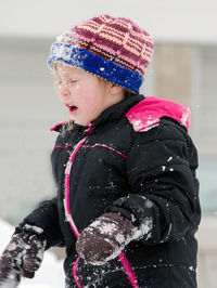 Young girl is surprised as she is hit with a snowball in the face