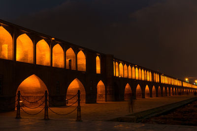 Arch bridge against sky at night