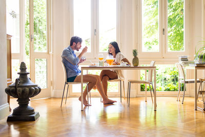 Friends sitting on table at home