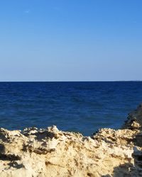 Scenic view of sea against clear blue sky