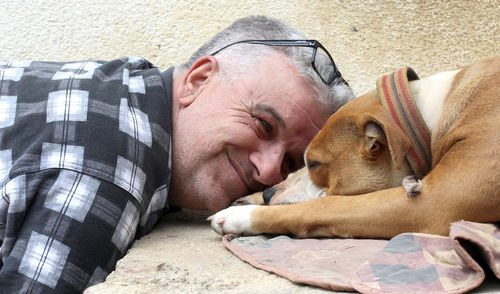 Close-up of man with sleeping dog